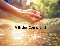 Human hand cupped to catch the fresh water from the river, reflection on water surface.